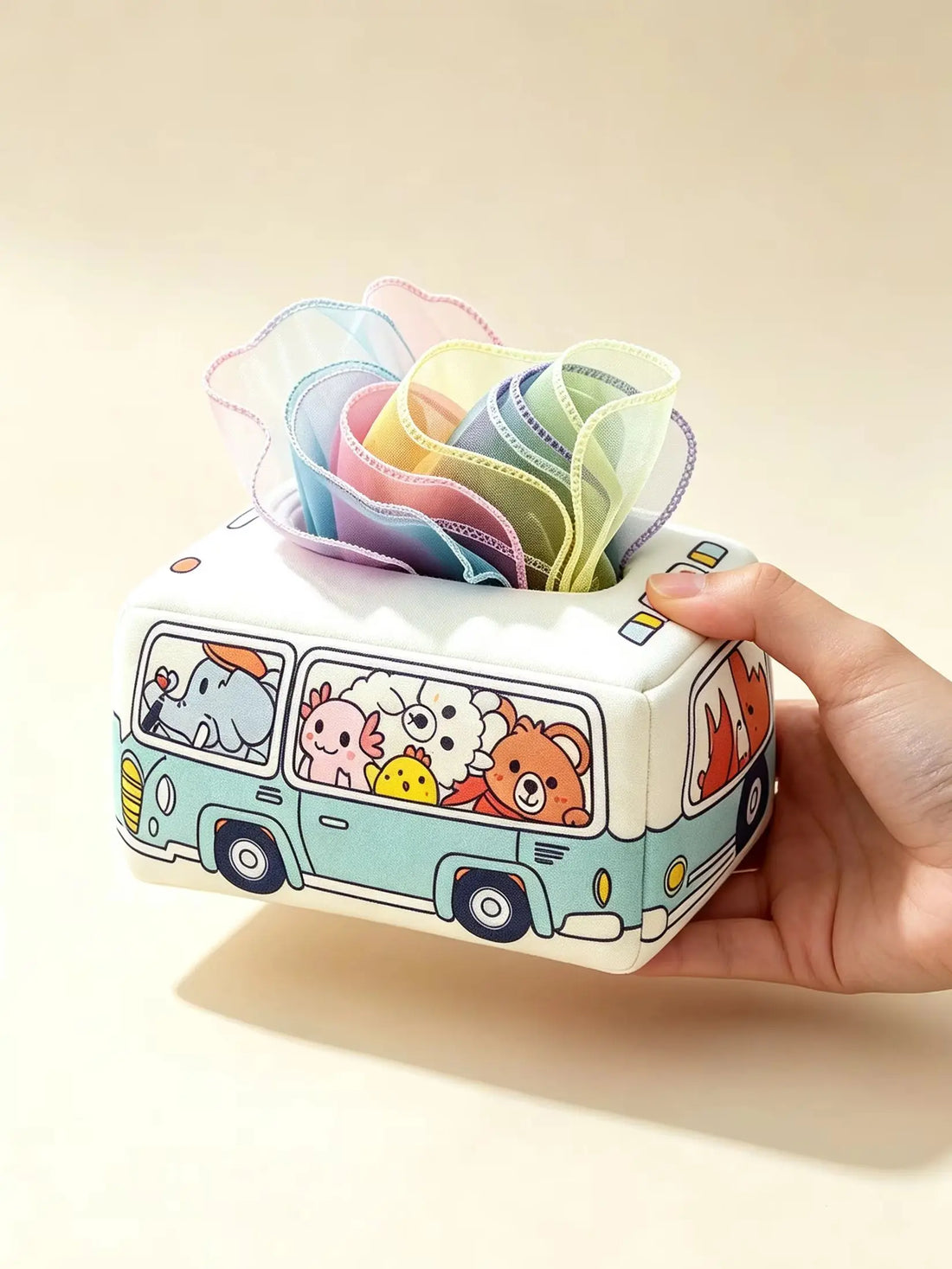 Baby sensory tissue box toy held in hand with coloured scarves