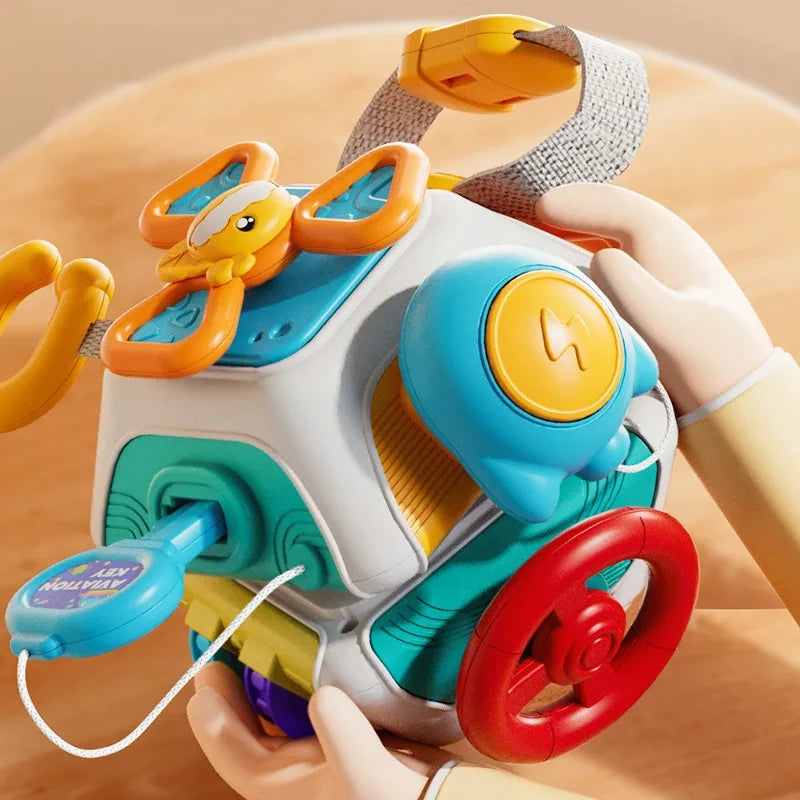 Toddler hands playing with a busy board cube