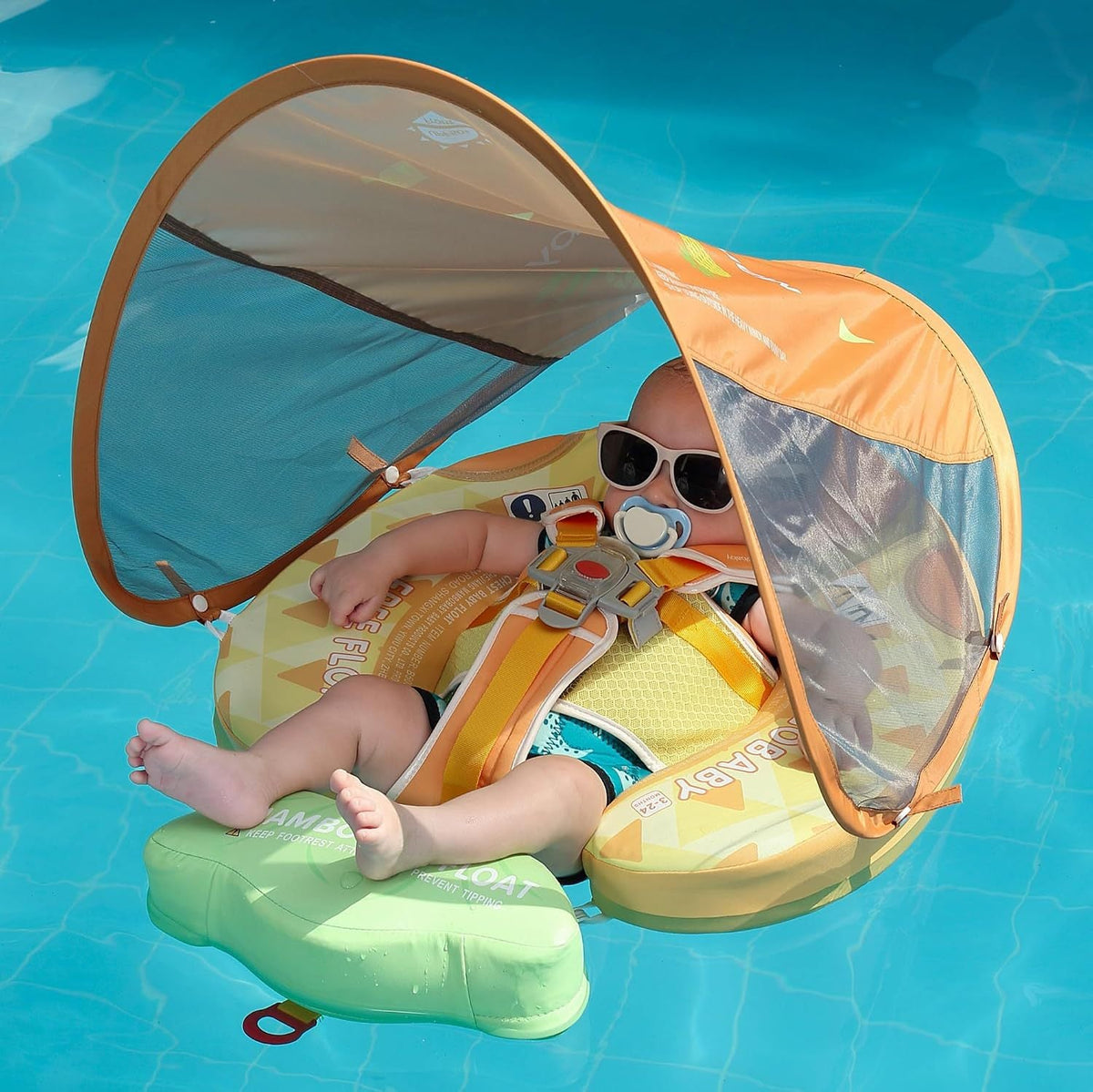 Baby resting in the Mambobaby Pineapple float in a pool, canopy up