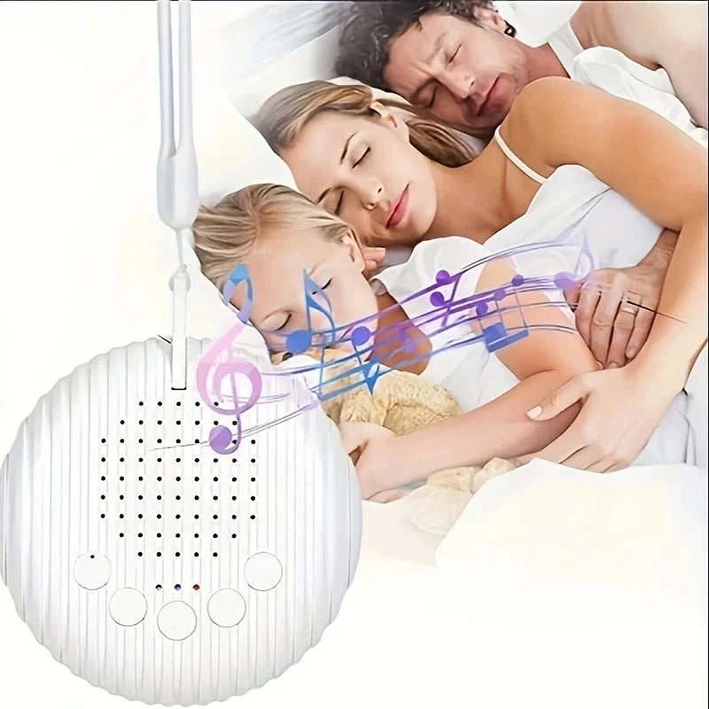 White noise machine on a bed beside a parent and baby
